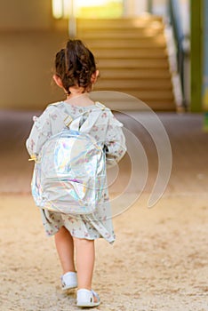 Back to school. Cute little child girl with backpack running and going to school with fun.