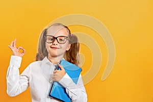 Back to school. A cute little girl with a book in glasses shows a sign approx.