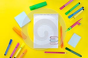 Back to school, drawing. Notebook checkered with pencil for notes to text with paper clips. Near pink, orange, green stationery.
