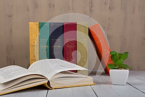 Back to school and education concept - heap colorful hardback books on white wooden table on brown background