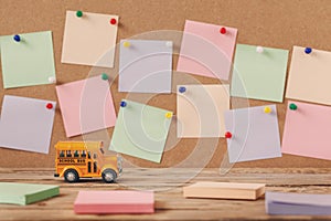 Back to school and Education concept. School bus toy with colorful notes for design on wooden background