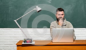 Back to school and Education concept. Student sitting at table and writing on notebook. Back to school. Bearded teacher.