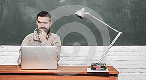 Back to school and Education concept. Student sitting at table and writing on notebook. Back to school. Bearded teacher.