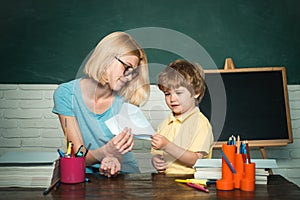 Back to school and Education concept. Teacher helping young boy with lesson. Child from elementary school with book.