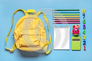 Back to school, education concept Yellow backpack with school supplies - notebook, pens, eraser rainbow, numbers