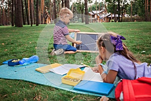 Back to school. Elementary scholars sitting on the grass during their open air class