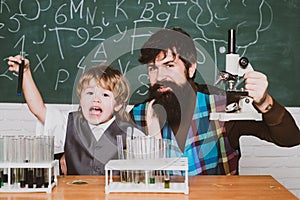 Back to school. Elementary school teacher and student in classroom. Home schooling. Father teaching her son chemistry or