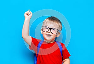 Back to school First grade junior lifestyle. Small boy in red t-shirt. Close up studio photo portrait of smiling boy in glasses