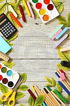 Back to school. Flatlay background. Table with autumn leaves and different school supplies, stationery, pencils.