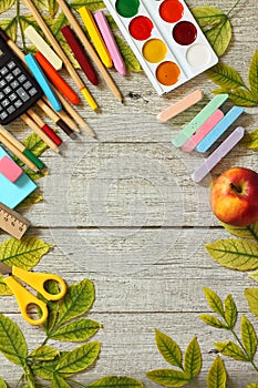 Back to school. Flatlay background. Table with autumn leaves and different school supplies, stationery, pencils.