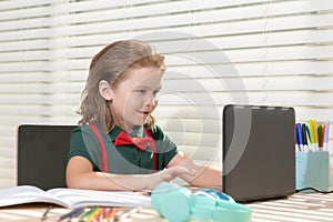 Back to school. Funny school boy from elementary school with book and laptop. Education. Kid with school supplies.