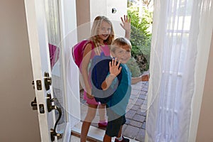 Back to school: Girl and boy walking out the front door