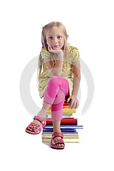 Back to school. Girl sitting on a stack of books