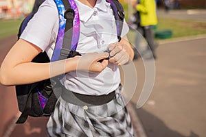 Back to school. Girl in uniform with parent go to school with backpack behind their backs. Beginning of lessons. First