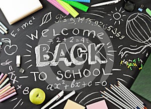 `Back to school` handwritten with school supplies on a black background