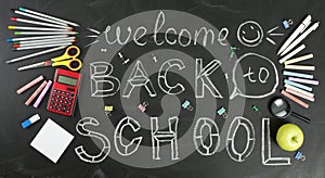 `Back to school` handwritten with school supplies on a black background.