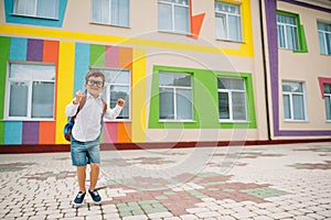 Back to school. Happy smiling boy in glasses is going to school for the first time. Child with backpack and book