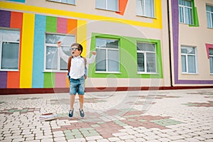 Back to school. Happy smiling boy in glasses is going to school for the first time. Child with backpack and book