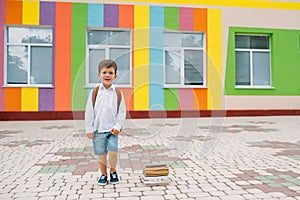 Back to school. Happy smiling boy in glasses is going to school for the first time. Child with backpack and book