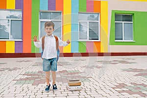 Back to school. Happy smiling boy in glasses is going to school for the first time. Child with backpack and book