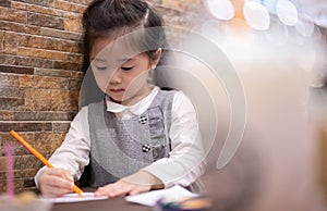 Back to school. Happy smiling pupil drawing at the desk. Cute little preschooler child drawing at home. Kid girl drawing with penc