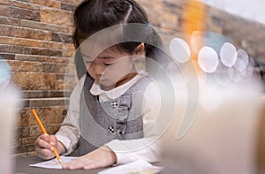 Back to school. Happy smiling pupil drawing at the desk. Cute little preschooler child drawing at home. Kid girl drawing with penc