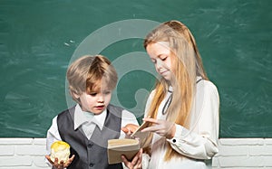 Back to school and happy time. Education first. Schoolgirl helping pupils studying at desks in classroom. Teacher