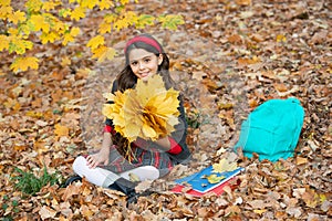 back to school. kid with notebook. fall season fashion. teen girl in uniform hold autumn leaves.