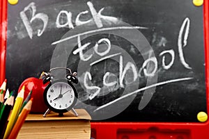 Back to school lettering on blackboard with piece of chalk