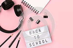 Back to school. Lightbox with letters, headphones and stationery.