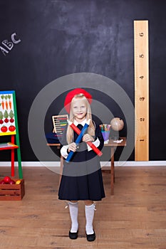 Back to school! A little girl stands with large pencils in her hands at school. School Girl responds to the lesson. The kid is stu