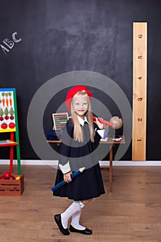 Back to school! A little girl stands with large pencils in her hands at school. School Girl responds to the lesson. The kid is stu