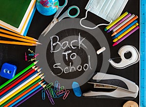 Back to School message on chalkboard with school supplies