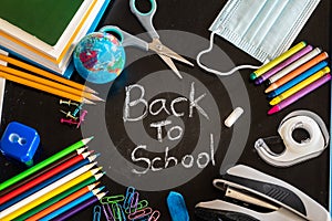 Back to School message on chalkboard with school supplies