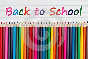 Back to School message with color pencils crayons on vintage ruled line notebook paper