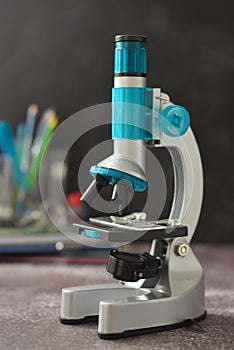 Back to school. Microscope isolated on black background. Studying biology at school laboratory