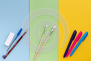 Back to school, minimalism concept. School supplies. Brushes for painting, pen, pencil, eraser, felt-tip pens on trendy blue green