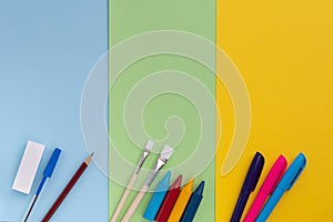 Back to school, minimalism concept. School supplies. Brushes for painting, pen, pencil, eraser, felt-tip pens on trendy blue green