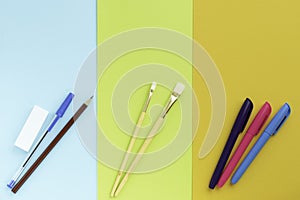 Back to school, minimalism concept. School supplies. Brushes for painting, pen, pencil, eraser, felt-tip pens on trendy blue green