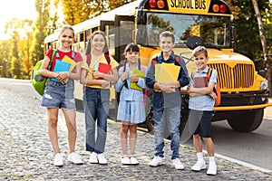 Back To School. Multiethnic Group Of Children Posing Outdoors Near School Bus