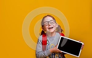 Back to school. Online education concept. Happy child with tablet computer. Kid showing screen. Smiling girl in
