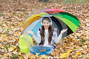 Back to school. online education. seasonal weather. happy kid wear headphones under umbrella. girl listen music with