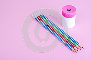 Back to school. Pencils, pencil sharpener on bright pink background. Place for text.