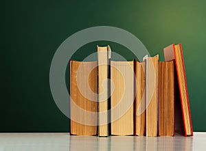 Back to school, pile of books with empty green school board background, education concept