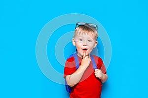 Back to school Portrait of happy surprised kid in glasses isolated on blue background with copy space. new school knowledges