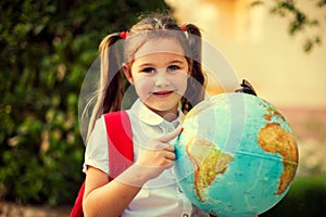 Back to school. Pupil girl with globe outdoor. Geography and education concept