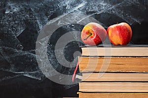 Back to school, Apple fruits on top of Book on Stack of Books with chalk board as background