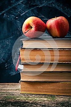 Back to school, Red Apple fruits on top of Book on Stack of Books with chalk board