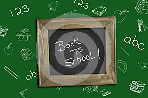 Back to school. School supplies at the table. Green background. Chalkboard