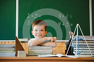 Back to school. A schoolboy is reading a book while sitting at the table for the first time at school on the background of the